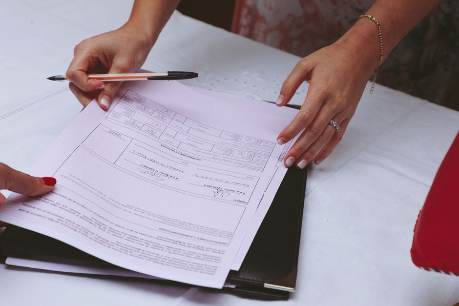 A detailed view of hands working with documents and a pen on a desk, ideal for business themes.
